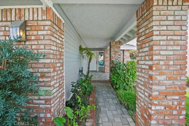 a view of house with potted plants next to a road