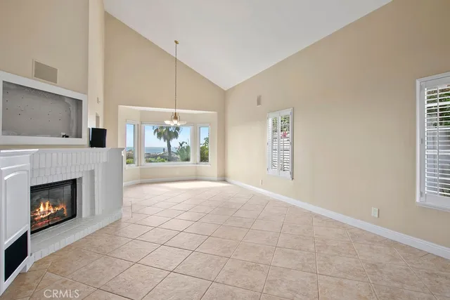 a view of an empty room with a fireplace and a window