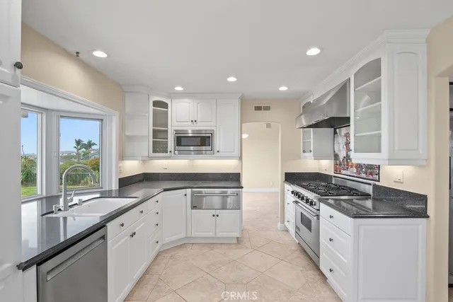 a kitchen with white cabinets and appliances