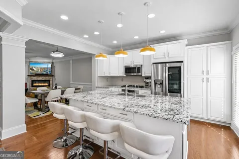 a kitchen with stainless steel appliances granite countertop a sink and a refrigerator
