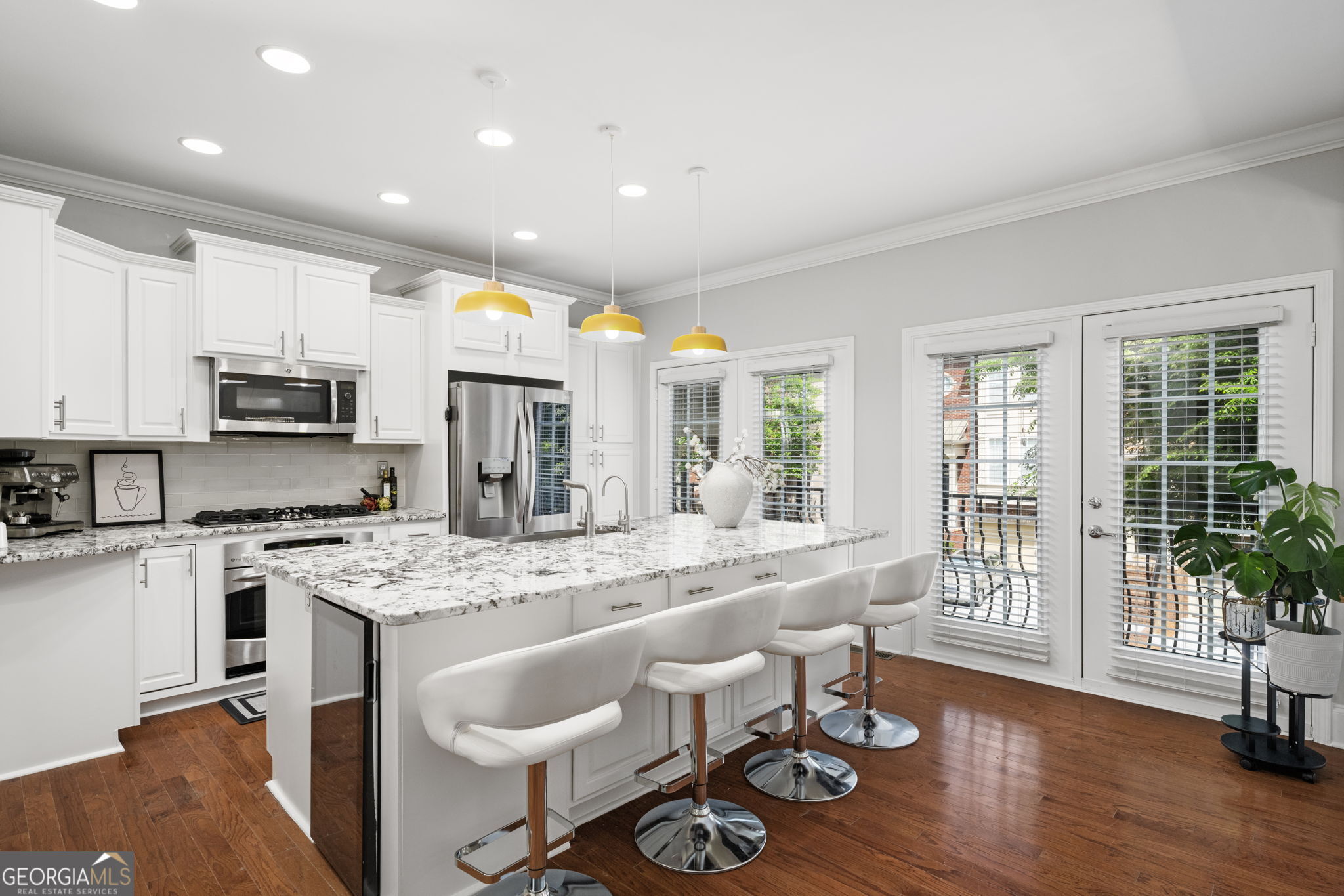 2872 Overlook Way Northeast Atlanta, GA 30324 - Photo 7 of 43 a large white kitchen with stainless steel appliances granite countertop a stove a sink a refrigerator dining table and chairs with wooden floor