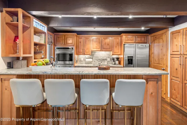 a dining table with chairs and view of kitchen