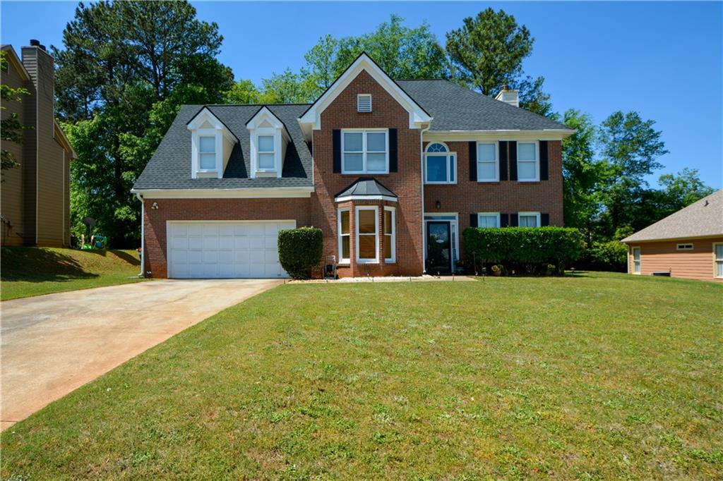 a front view of a house with a garden