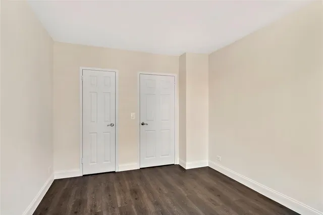 an empty room with wooden floor and window