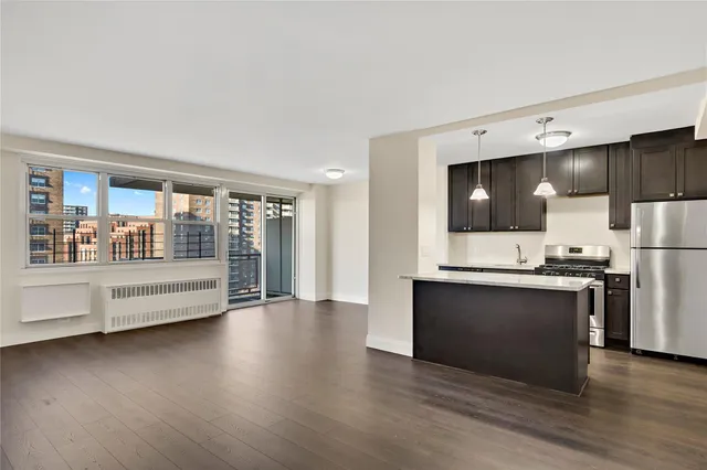 a view of kitchen with stainless steel appliances wooden floor and a large window
