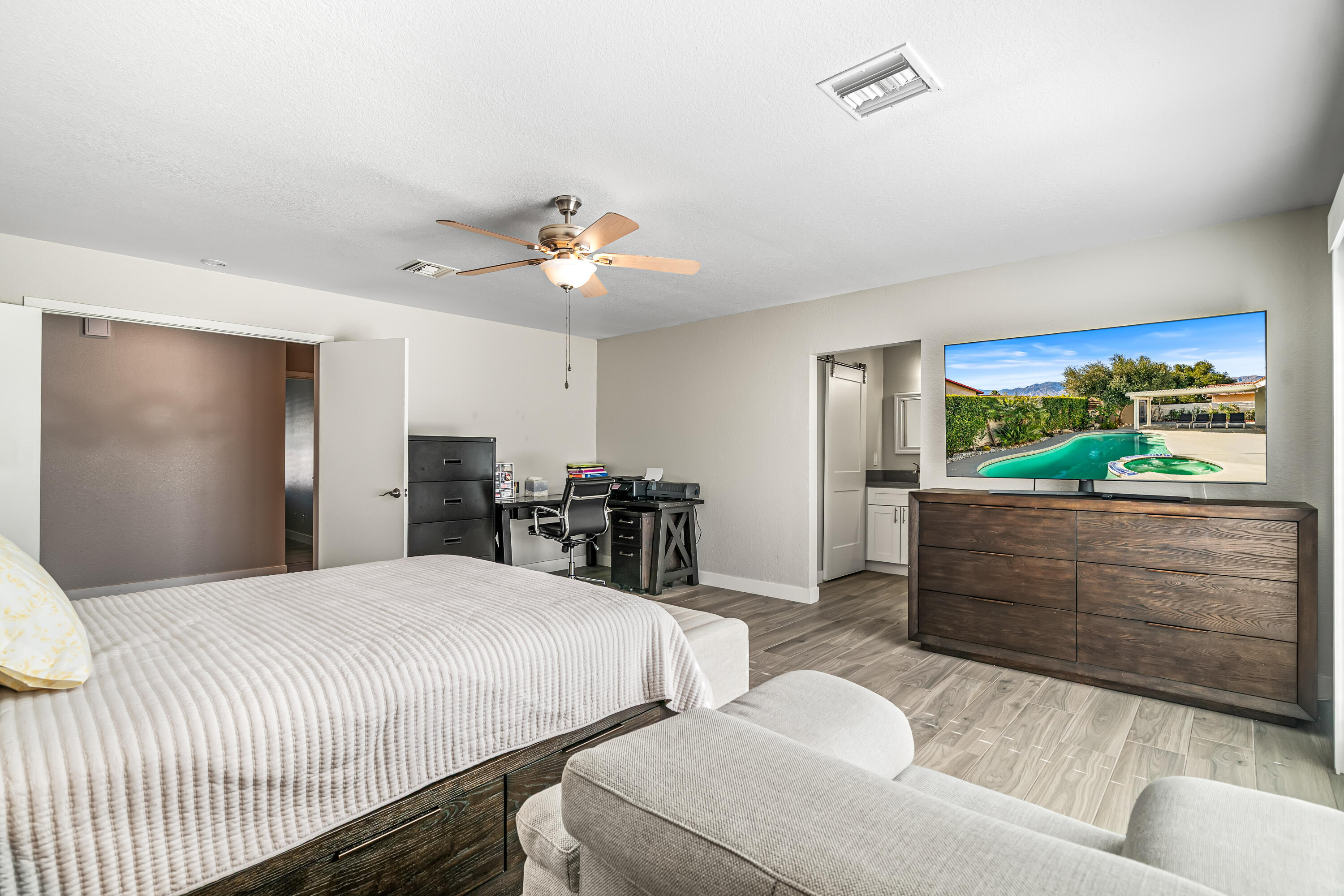 67265 Rango Road Cathedral City, CA 92234 - Photo 29 of 49 a bedroom with a bed and a chandelier