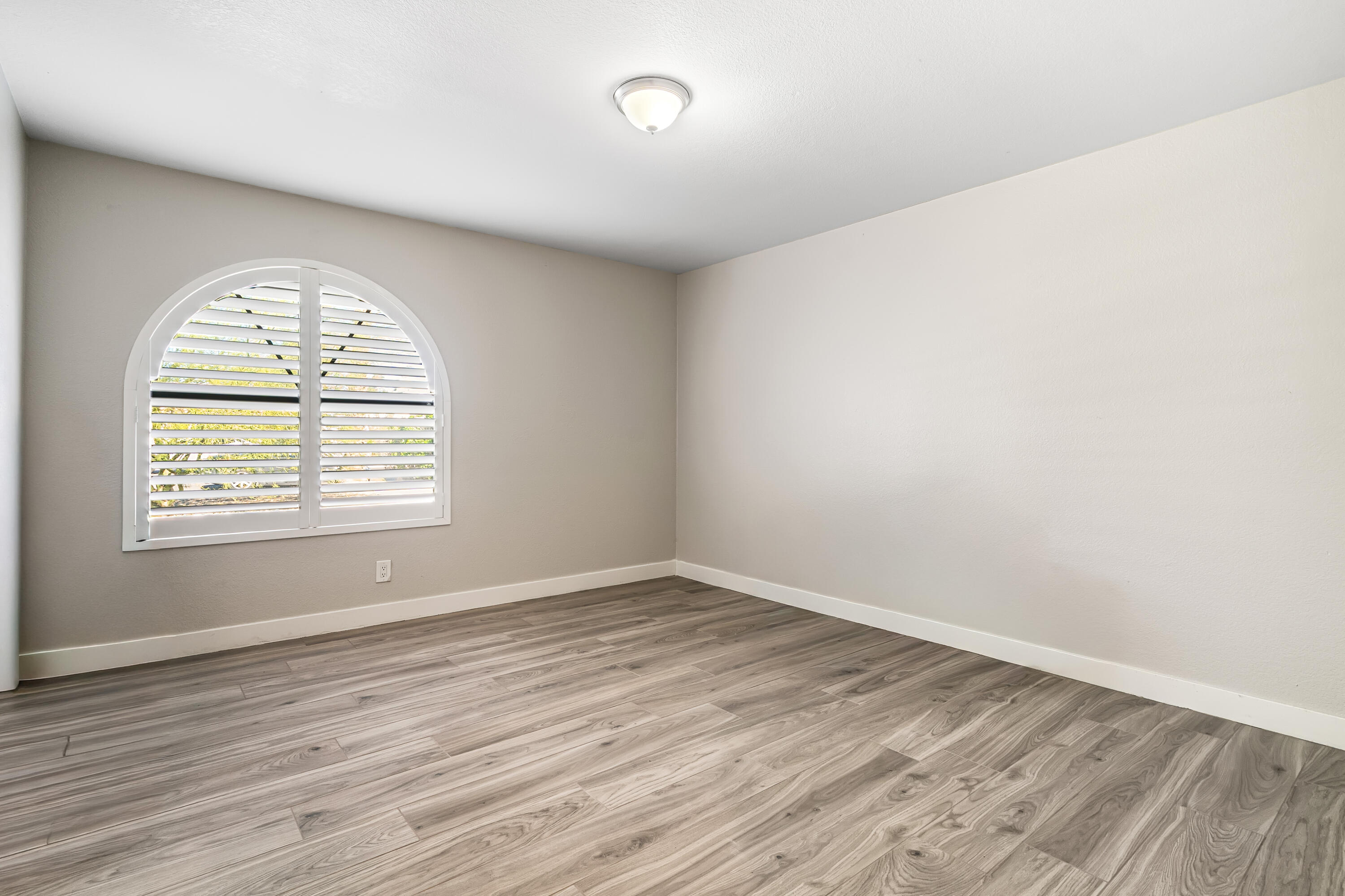 67265 Rango Road Cathedral City, CA 92234 - Photo 32 of 49 an empty room with wooden floor and windows