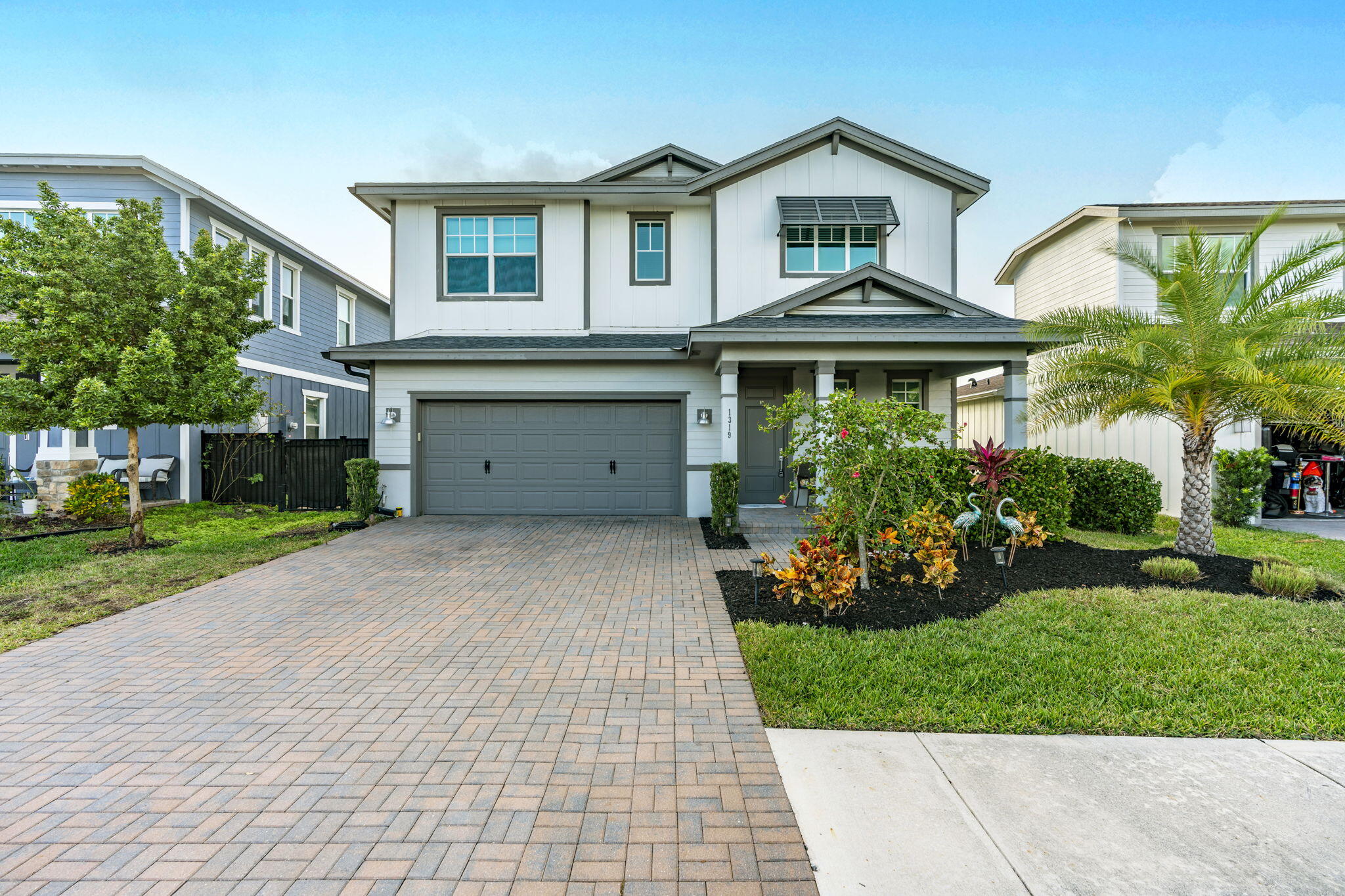 a front view of a house with a yard and potted plants
