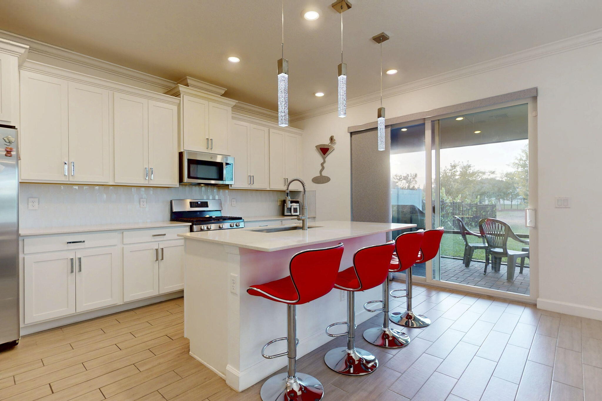 1319 Arrowhead Point Road Loxahatchee, FL 33470 - Photo 6 of 45 a kitchen with stainless steel appliances granite countertop a kitchen island hardwood floor sink stove dining table and chairs