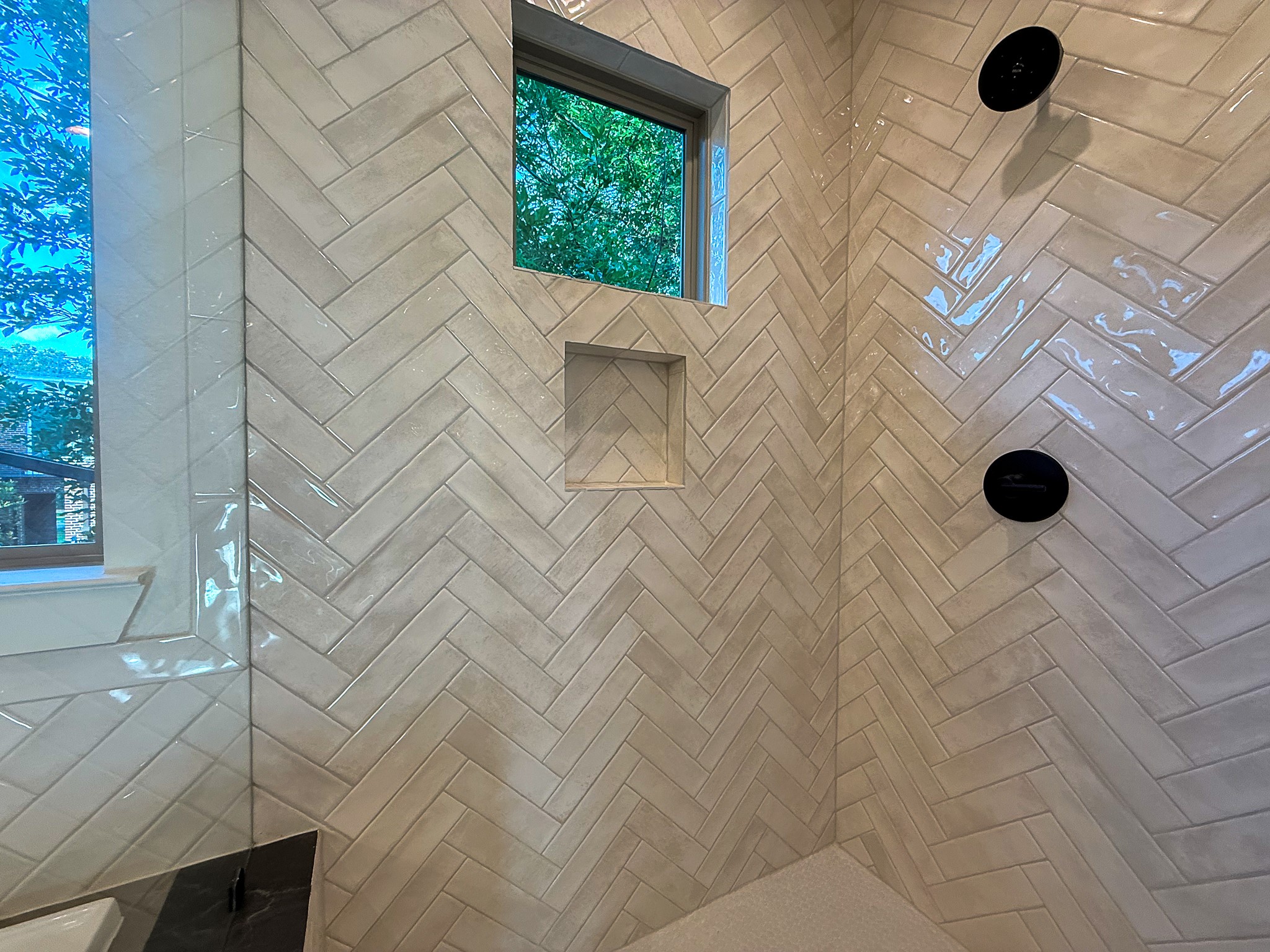 5329 Dora Street Houston, TX 77005 - Photo 27 of 43 The beautiful herringbone flows seamlessly into the spacious walk in shower. Premium craftsmanship is showcased in the clean lines and intricate tile alignment.