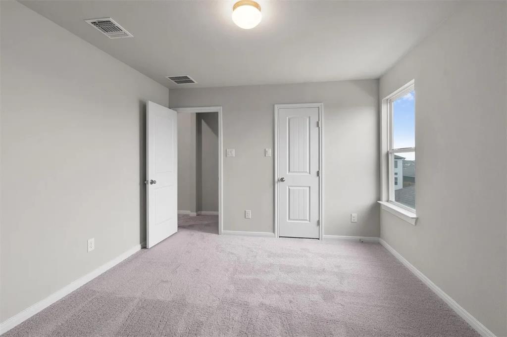 332 Stellar Wind Drive Georgetown, TX 78628 - Photo 4 of 29 A quiet bedroom offers plush carpeting, a wide window, and multiple entryways for comfort and ease.