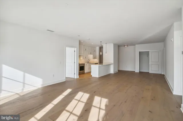 a view of a kitchen and an empty room