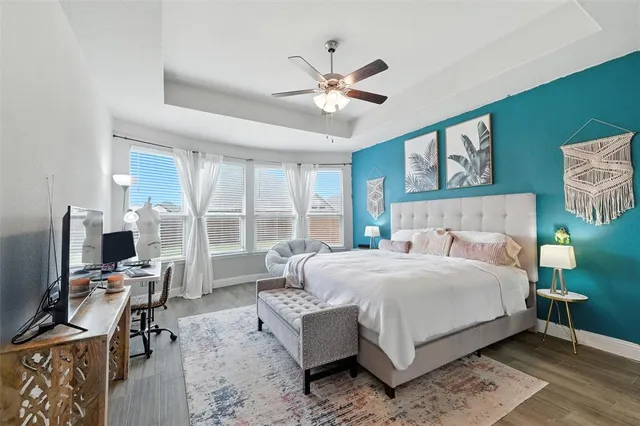 a bedroom with a bed large window with table and chair