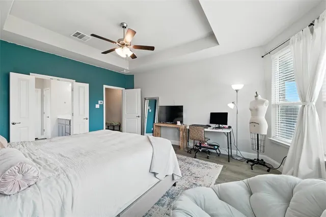 a spacious bedroom with a bed and a flat screen tv