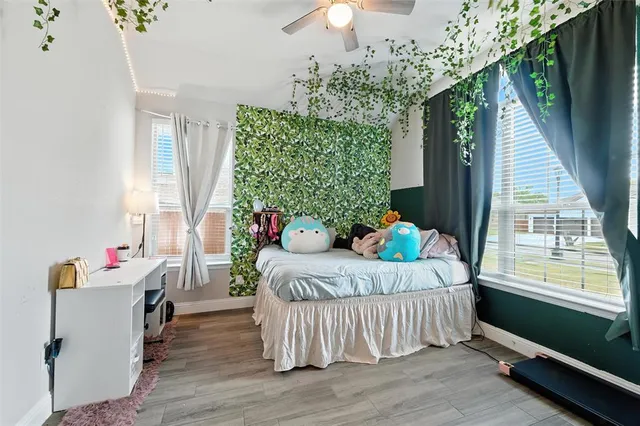 a bedroom with furniture and a large window