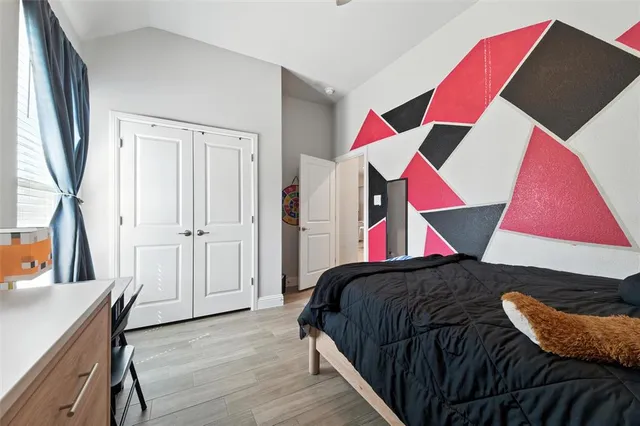 a bedroom with a bed and a painting on the wall