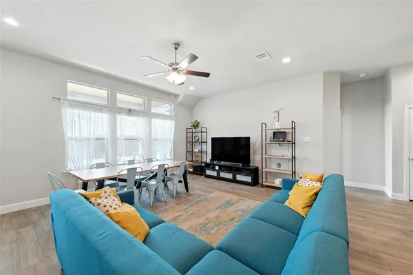 a living room with furniture kitchen view and a flat screen tv