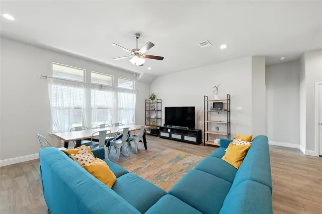 a living room with furniture kitchen view and a flat screen tv