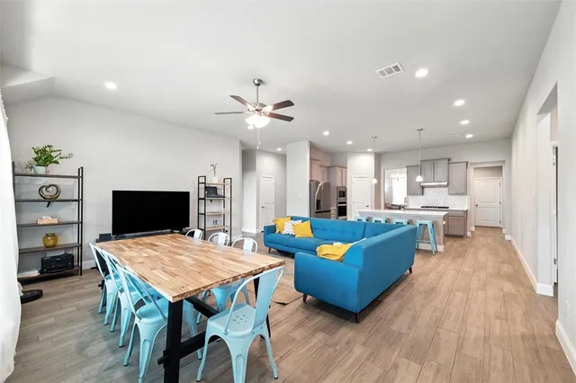 a living room with furniture and a wooden floor