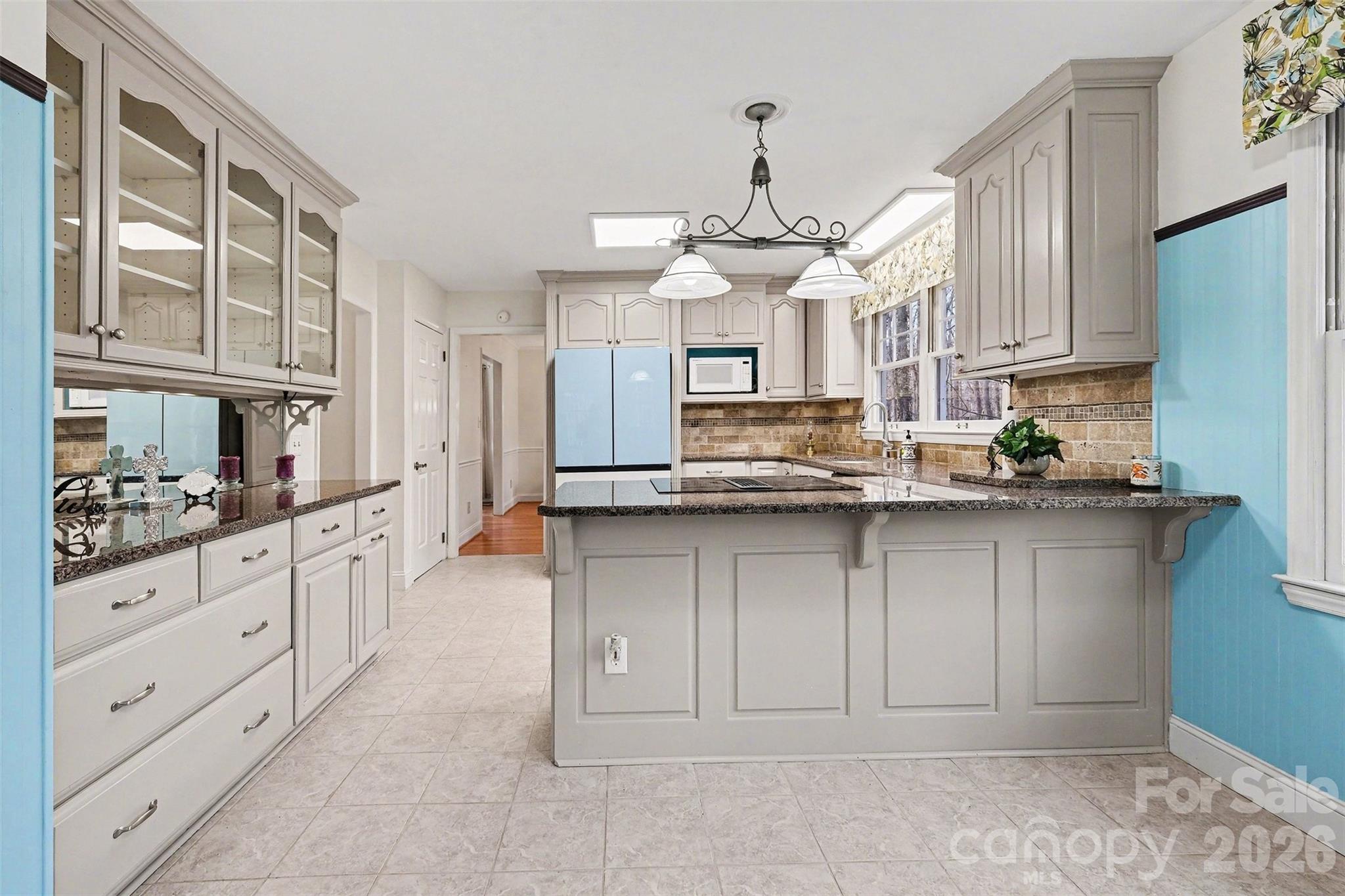 909 Woodland Forest Road Waxhaw, NC 28173 - Photo 4 of 38 a kitchen with kitchen island granite countertop a sink cabinets and stainless steel appliances