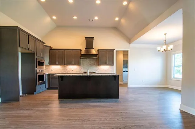a kitchen with stainless steel appliances granite countertop a sink and a refrigerator