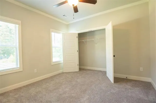 a view of an empty room and chandelier fan