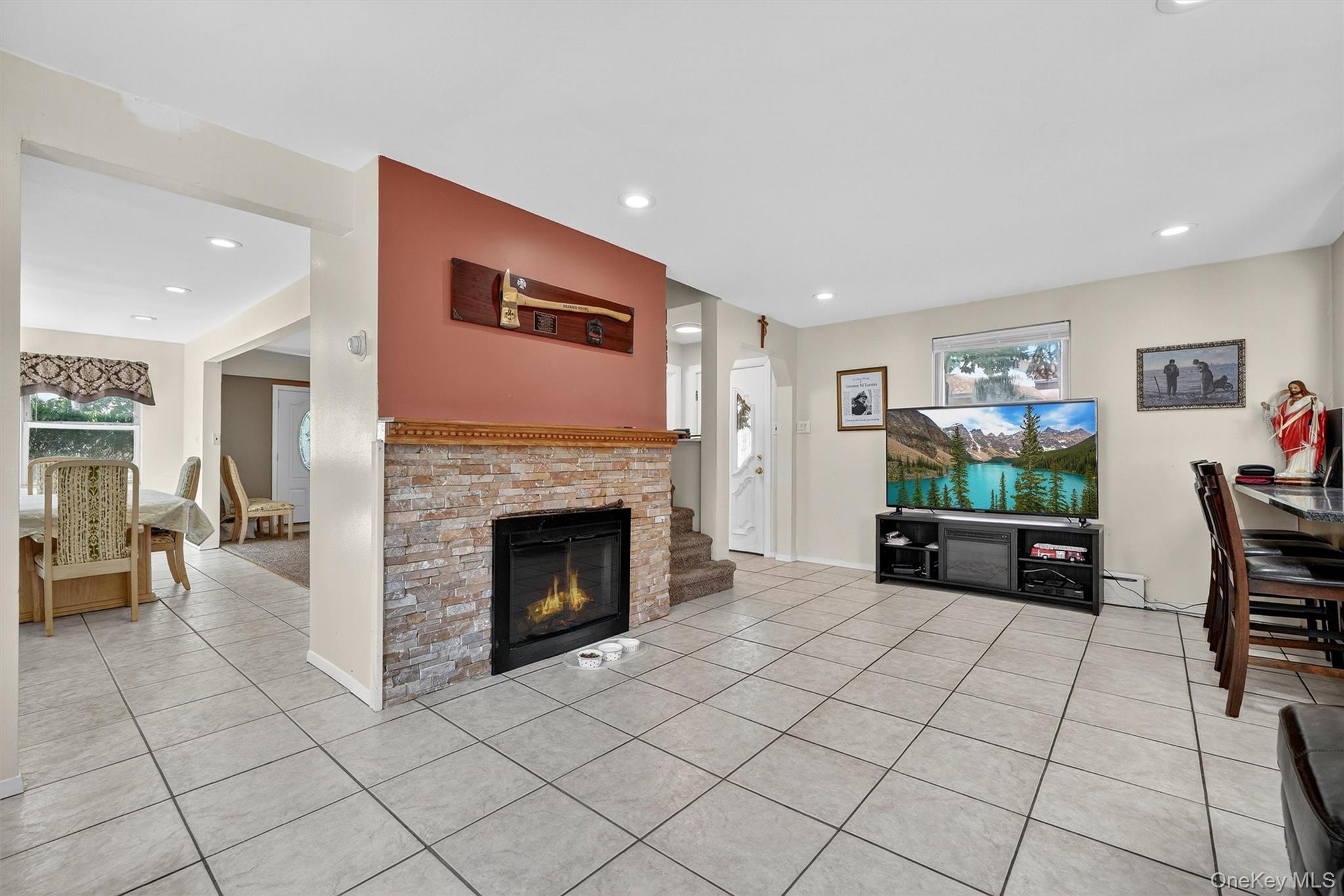 3384 Country Club Road Bronx, NY 10465 - Photo 19 of 48 Living room featuring light tile patterned flooring, a glass covered fireplace, recessed lighting, and a baseboard heating unit