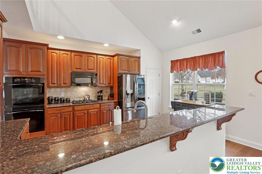 2076 Kingsview Road Lower Macungie Township, PA 18062 - Photo 22 of 53 a kitchen with stainless steel appliances granite countertop a stove top oven a sink and dishwasher