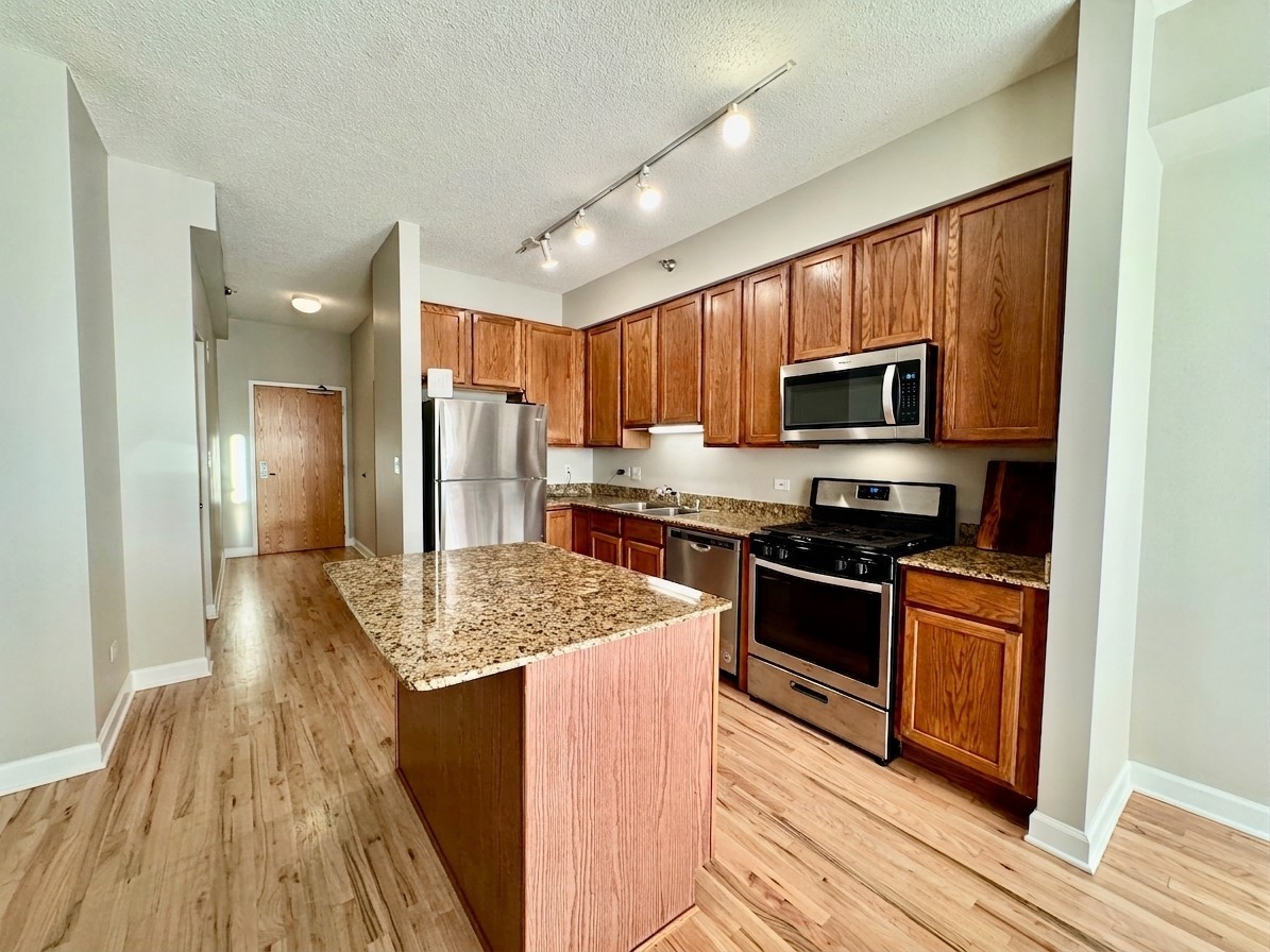 41 East 8th Street, Unit 1805 Chicago, IL 60605 - Photo 5 of 33 a kitchen with stainless steel appliances granite countertop a refrigerator stove microwave and sink