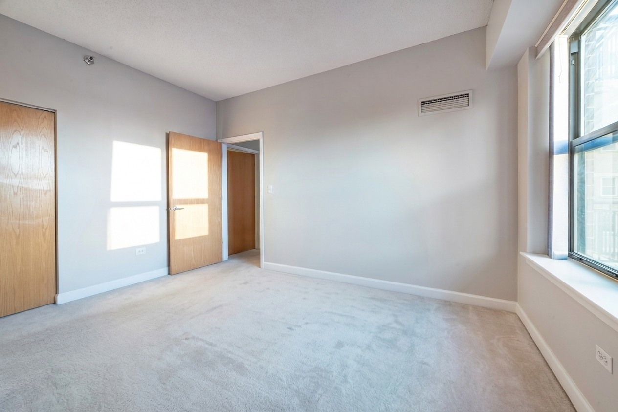 41 East 8th Street, Unit 1805 Chicago, IL 60605 - Photo 9 of 33 an empty room with windows and closet