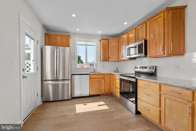 a kitchen with stainless steel appliances granite countertop a refrigerator sink and stove