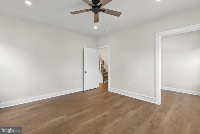 an empty room with fan and entryway