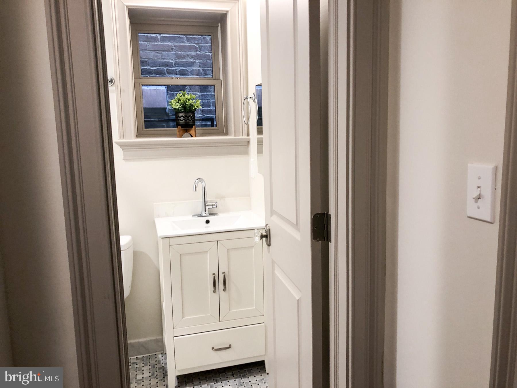 1302 East Capitol Street Northeast, Unit B Washington, DC 20003 - Photo 9 of 23 a bathroom with a sink a mirror and a window