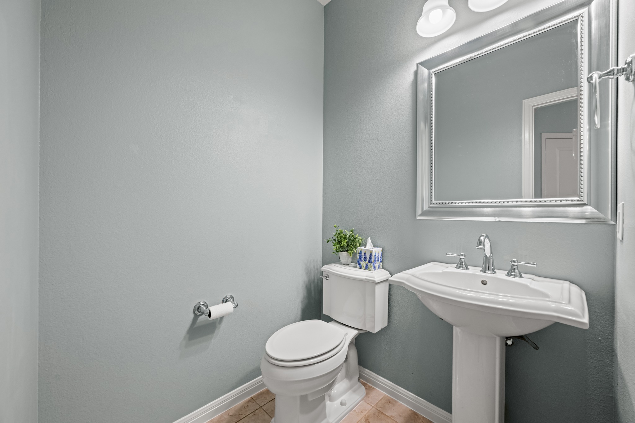 1023 Grassy Field Road Austin, TX 78737 - Photo 21 of 40 Powder Room includes pedestal sink with chrome fixtures, framed mirror with integrated lighting, and tile flooring