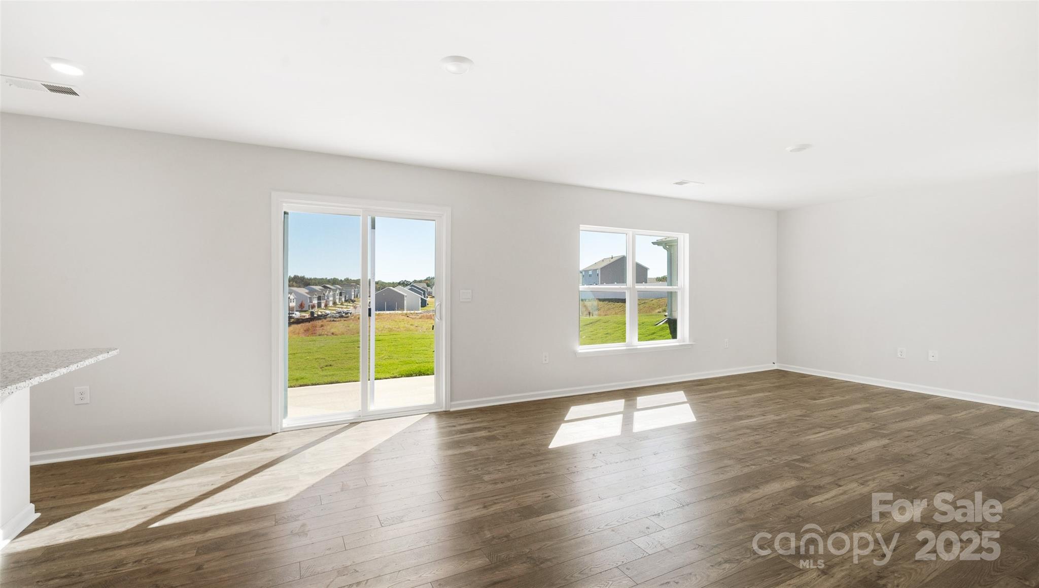 143 Callie River Clyde, NC 28721 - Photo 11 of 20 an empty room with wooden floor and windows