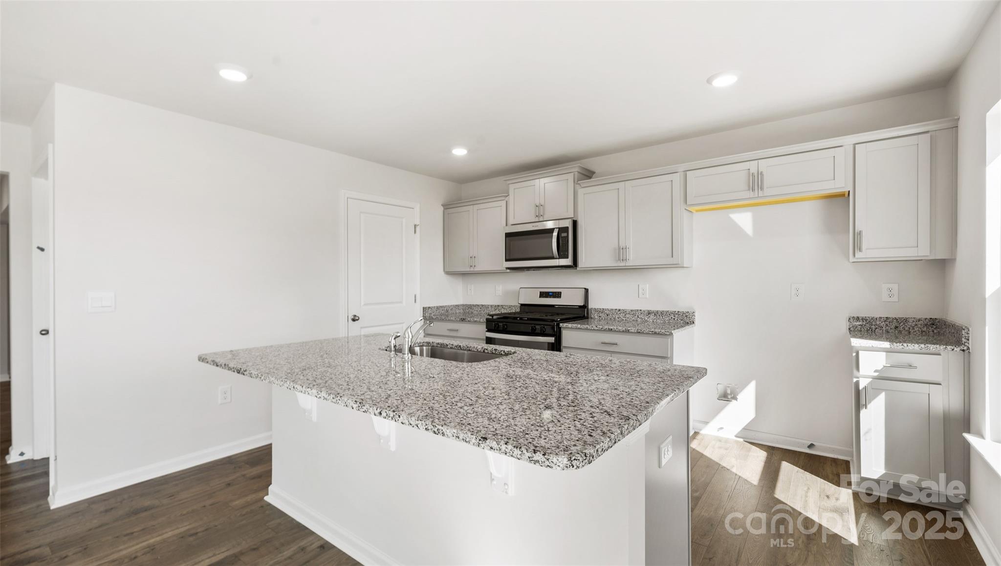 143 Callie River Clyde, NC 28721 - Photo 7 of 20 a kitchen with granite countertop kitchen island a sink appliances and cabinets