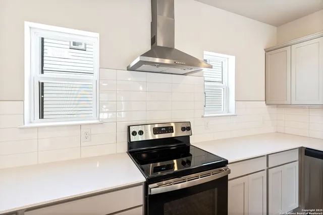a kitchen with a stove cabinets and a window
