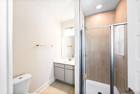 a bathroom with a shower a sink and a toilet