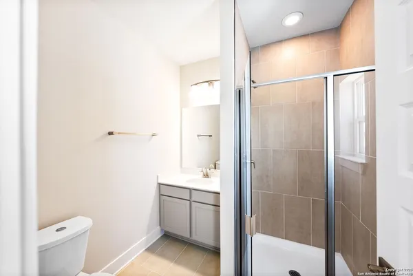 a bathroom with a shower a sink and a toilet
