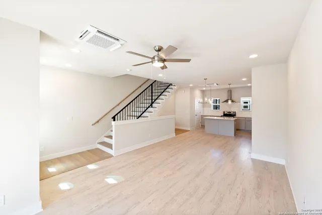 a view of a kitchen with wooden floor and a ceiling fan