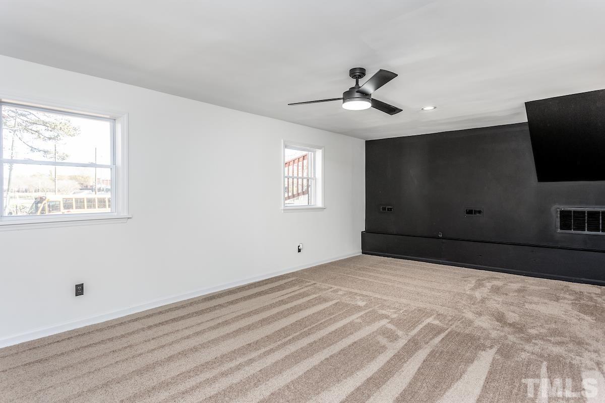 313 Lord Ashley Road Raleigh, NC 27610 - Photo 21 of 32 a bedroom with a large bed and a flat screen tv