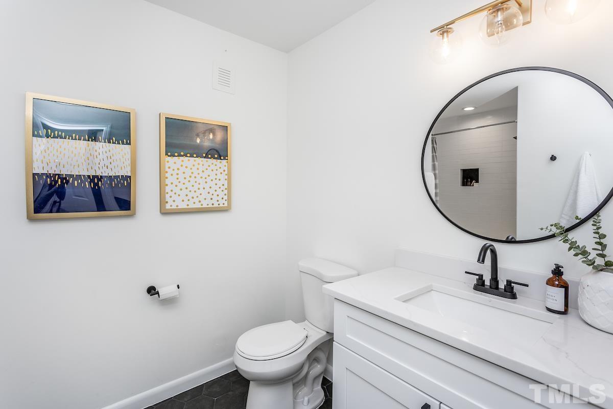 313 Lord Ashley Road Raleigh, NC 27610 - Photo 24 of 32 a bathroom with a sink mirror and toilet