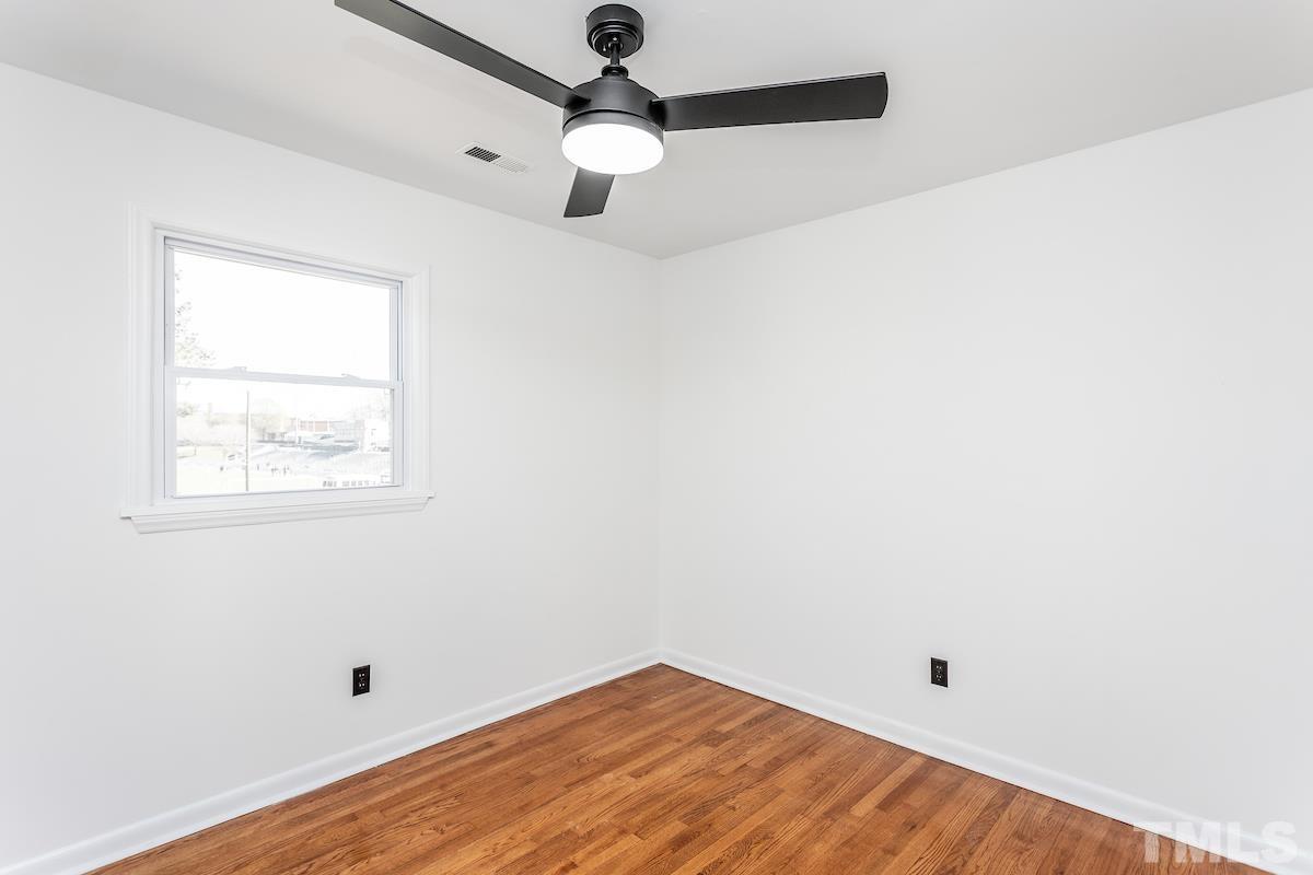 313 Lord Ashley Road Raleigh, NC 27610 - Photo 25 of 32 an empty room with a window and a ceiling fan