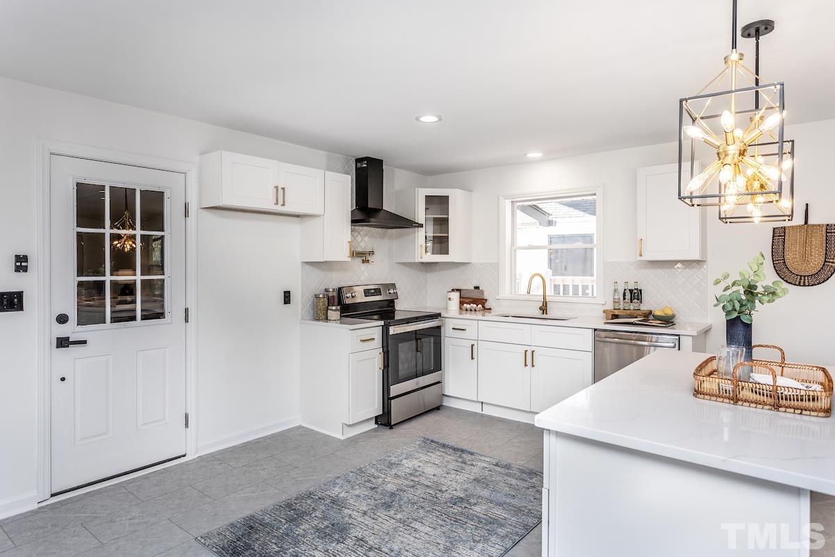 313 Lord Ashley Road Raleigh, NC 27610 - Photo 6 of 32 a kitchen with sink a stove and white cabinets