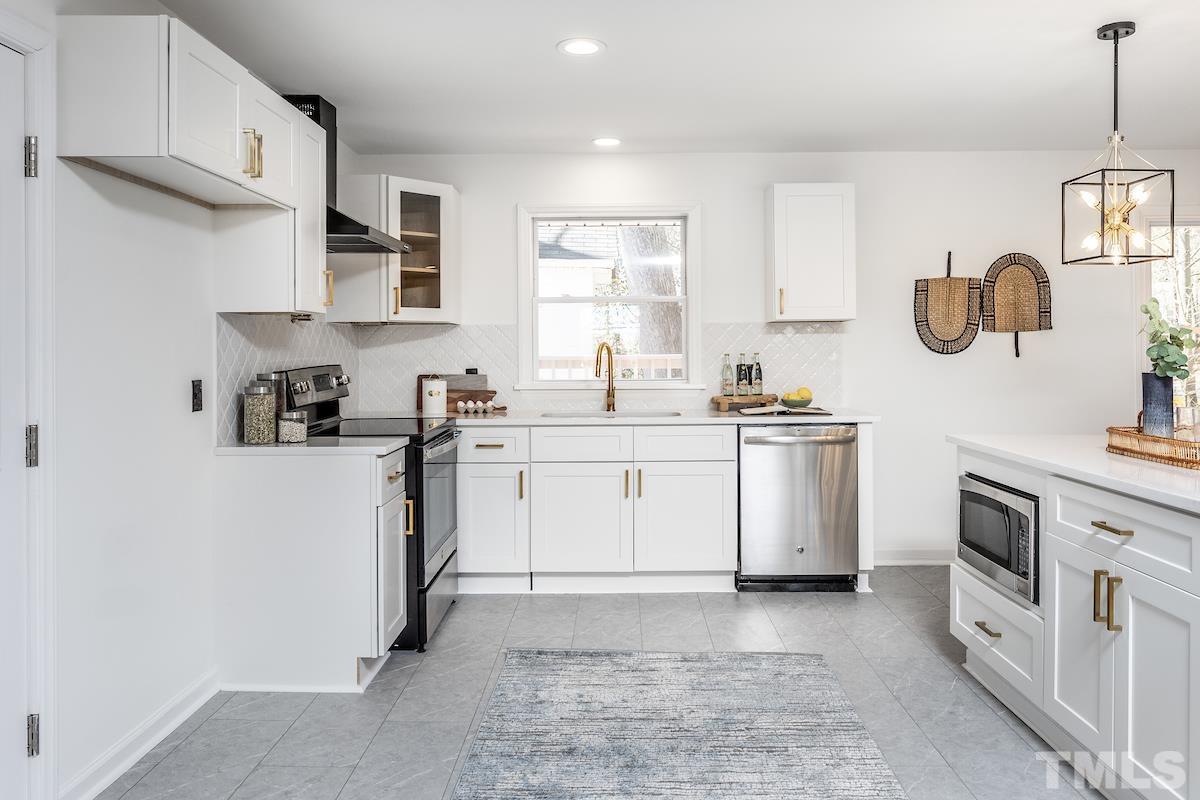 313 Lord Ashley Road Raleigh, NC 27610 - Photo 7 of 32 a kitchen with white cabinets and white appliances