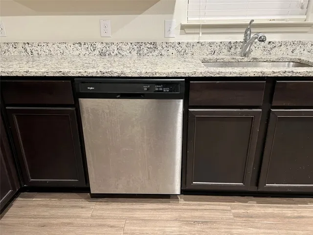 a kitchen with stainless steel appliances granite countertop wooden cabinets a refrigerator and a sink