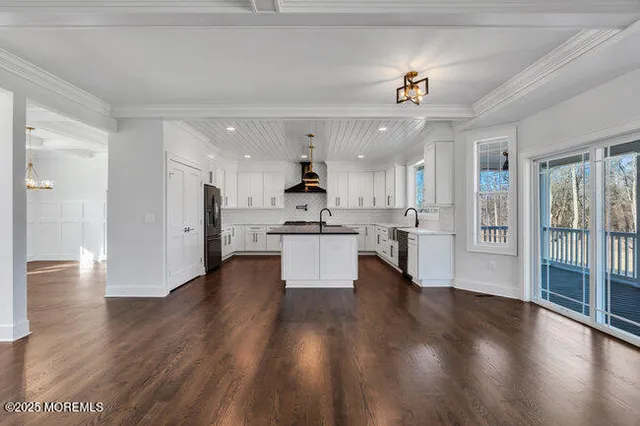 a kitchen with stainless steel appliances granite countertop a sink a stove and a wooden floor