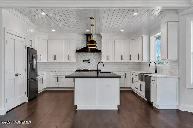 a kitchen with granite countertop a sink stainless steel appliances and cabinets