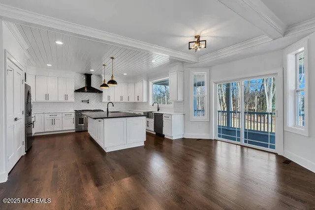 a kitchen with stainless steel appliances granite countertop a sink a stove and a wooden cabinets