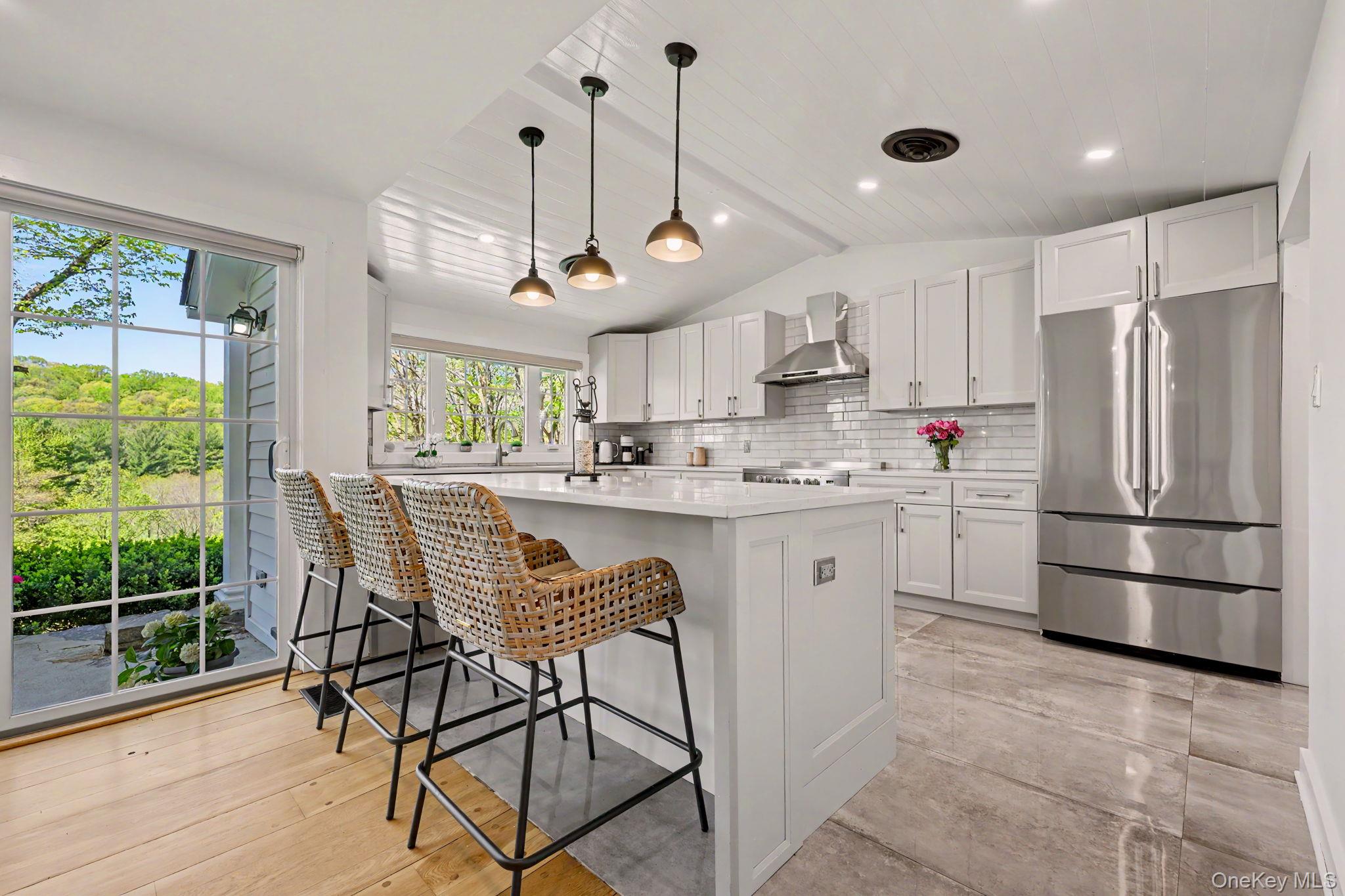 233 Long Ridge Road Bedford, NY 10506 - Photo 8 of 50 a kitchen with stainless steel appliances granite countertop a refrigerator a sink dishwasher a stove a dining table and chairs with wooden floor